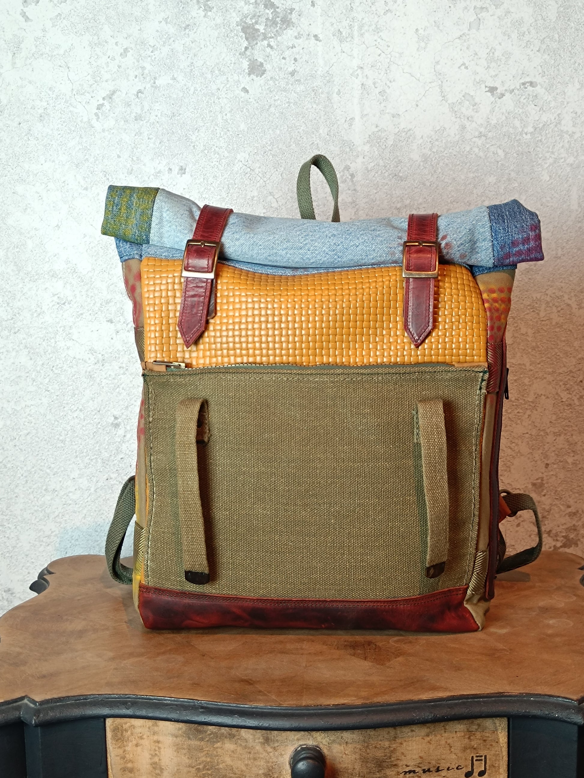 Multicolored backpack with leather straps on a wooden surface