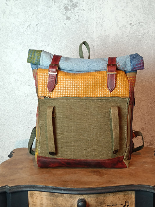 Multicolored backpack with leather straps on a wooden surface