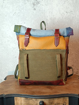 Multicolored backpack with leather straps on a wooden surface