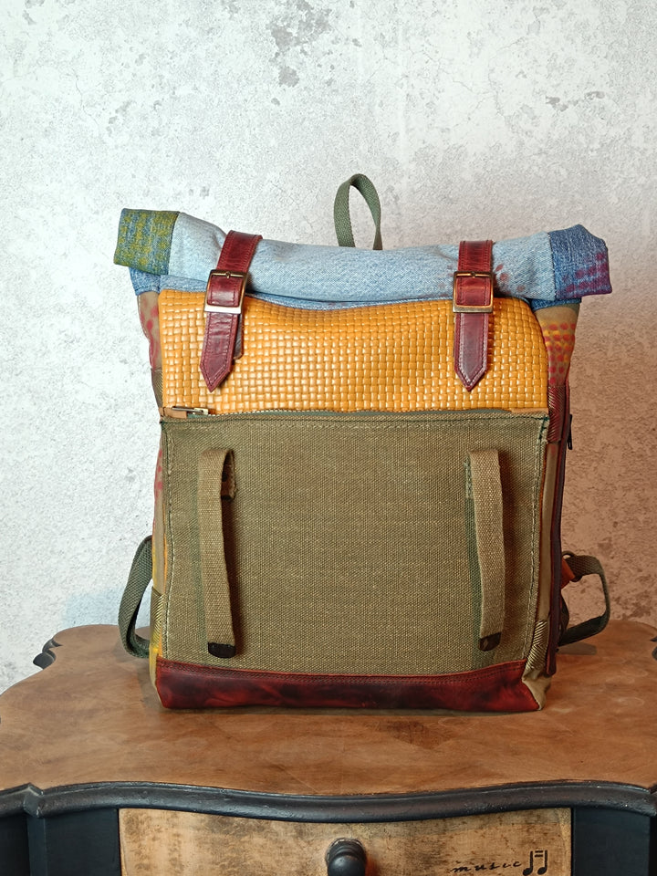 Multicolored backpack with leather straps on a wooden surface